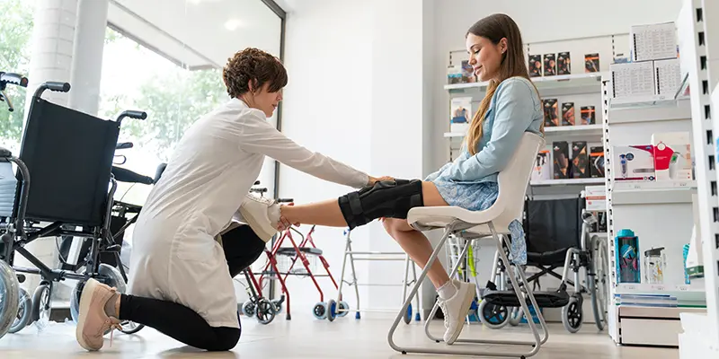 woman putting brace on young girl